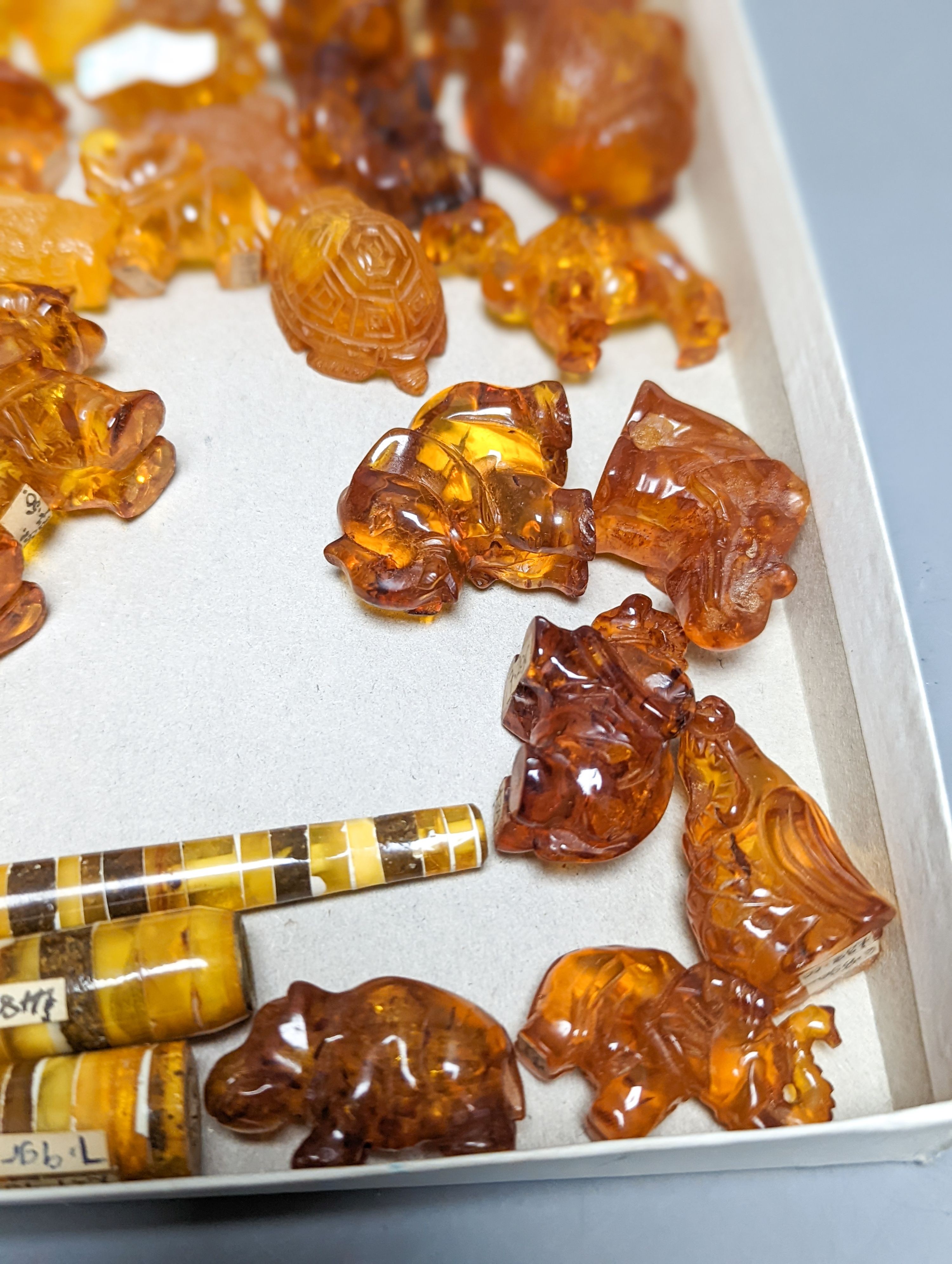 A mixed collection small carved amber wares including dice, eggs and cigarette holders, etc.